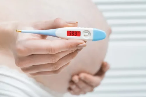 Gravid kvinde med feber, hvilket kan skyldes problemer med fostervand