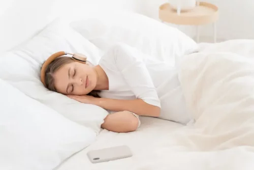 Kvinde sover med hovedtelefoner på