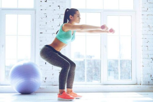 Kvinde laver squat for at styrke sine benmuskler