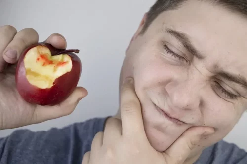 Mand spiser æble og oplever følsomme tænder grundet parodontitis