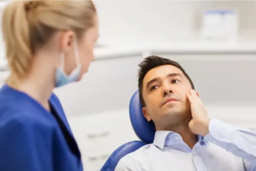 Mand ved tandlæge grundet tandpine forårsaget af pulpitis