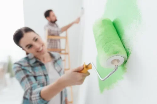 Par maler en væg grøn