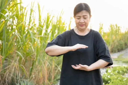 En person dyrker tai chi udenfor