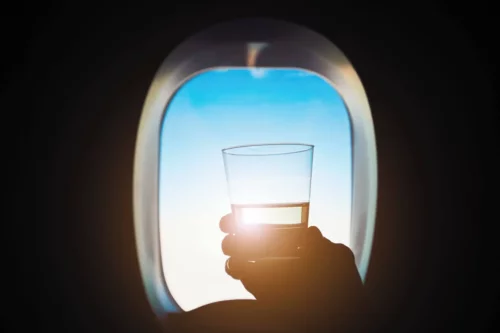 Et glas vand foran et flyvindue