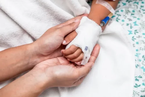 Et barns hånd med drop modtager ny behandling af kræft