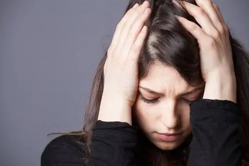 Kvinde har hovedpine, som er en af de mest almindelige lidelser