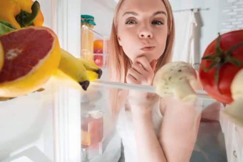 Kvinde kigger i køleskab