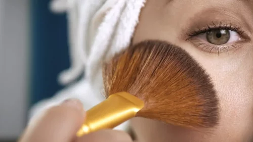 Kvinde påfører makeup omkring øjet