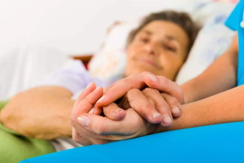 En patient holdes i hånd