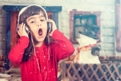 Pige synger julesange, da det er en af de ting, børn kan lære af julen