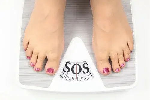 Kvinde på vægt, der viser SOS, har brug for måder at forebygge fedme på