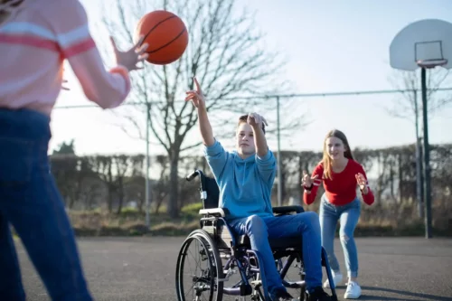 Dreng i kørestol spiller basket som eksempel på motion til personer med begrænset mobilitet