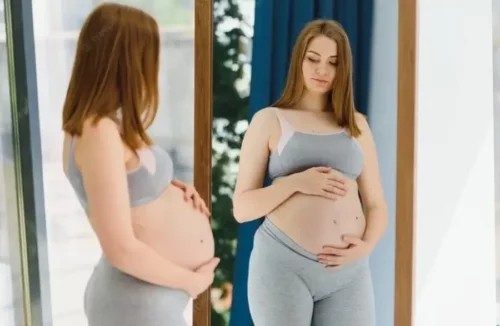Gravid kvinde foran spejl