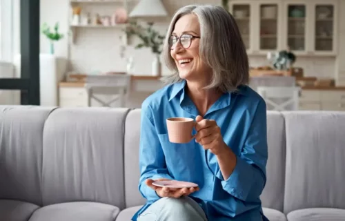 Smilende kvinde nyder en kop kaffe