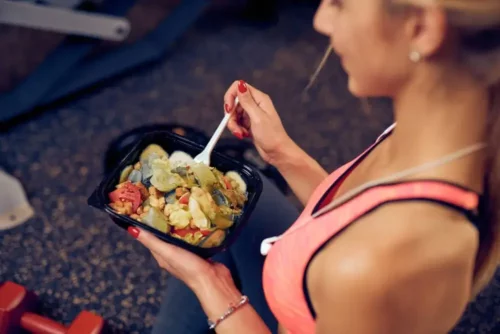 Kvinde spiser en salat efter træning