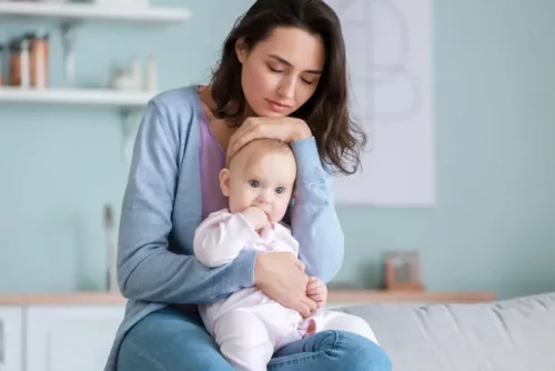 En mor, der krammer sin baby, får os til at tænke på tilknytningsteorien