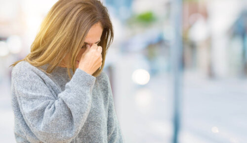 En træt mor tager sig til hovedet