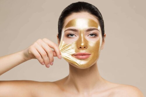 Kvinde med ansigtsmaske af guld til at beskytte hudbarrieren