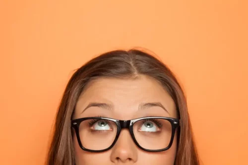 Kvinde med briller på kigger op