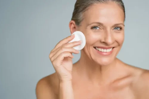 Kvinde renser ansigt som en del af at fjerne solcreme