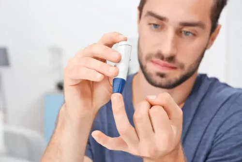 Mand måler sit blodsukkerniveau