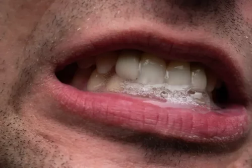 Nærbillede af spyt i en mands mund