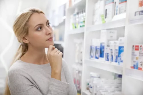 Kvinde på apotek kigger på lægemidler med squalane
