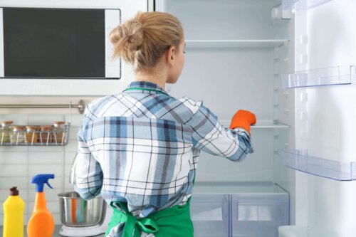 Kvinde rengør køleskab, da rengøring kan reducere stress