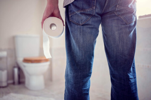 Mand står på badeværelse med toiletpapir