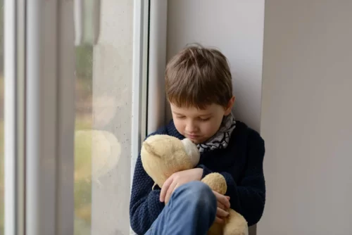 Trist dreng krammer en bamse