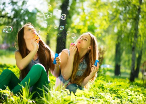 To unge kvinder puster sæbebobler udenfor