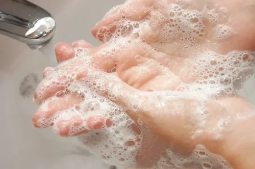 Person prøver at vaske hænder for at fjerne silikone