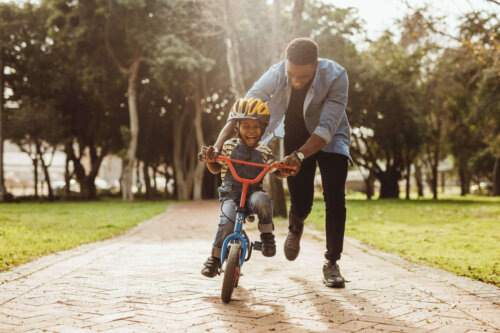 En far lærer sit barn at cykle