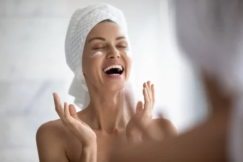Kvinde påfører ansigtscreme i omvendt hudpleje