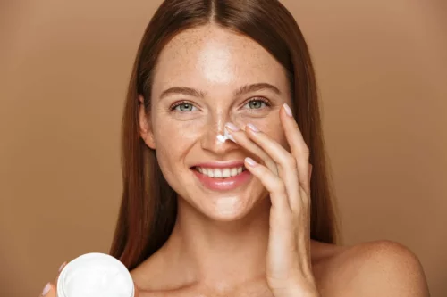 Kvinde påfører ansigtscreme som en del af anti-konturering