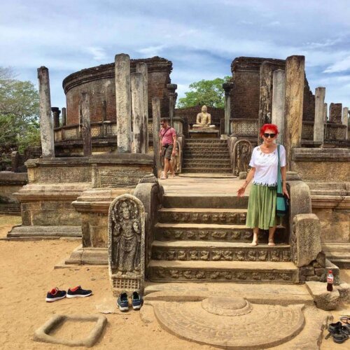 Kvinde står ved gamle ruiner på en rejse