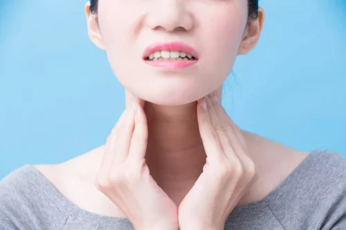 Kvinde med smerter i hals grundet skjoldbruskkirtelsygdomme