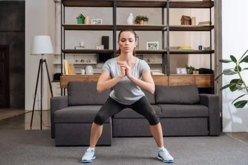 Kvinde squatter som eksempel på excentrisk træning af benene