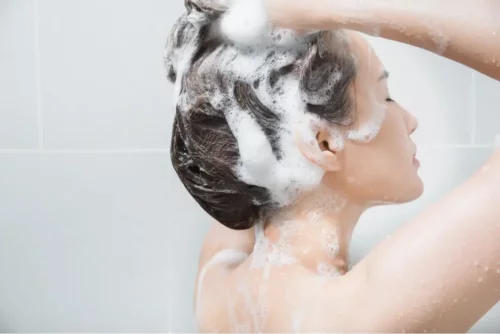 Kvinde vasker hår for at opnå liquid hair