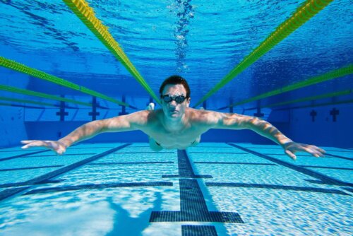 Mand svømmer for at komme i form fra bunden