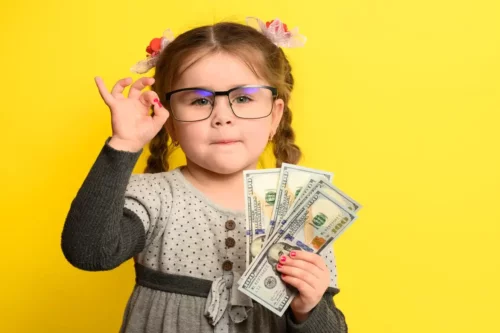 Lille pige med penge repræsenterer at lære børn om ansvarligt forbrug