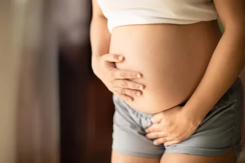 Gravid kvinde tager sig til maven