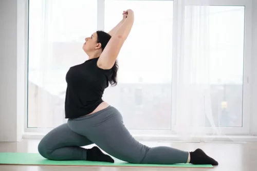 Kvinde dyrker yoga som eksempel på motion efter en fedmeoperation