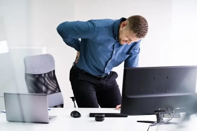Mand på kontor har rygsmerter