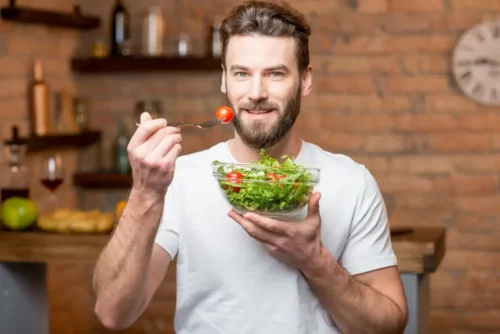 Mand spiser en salat