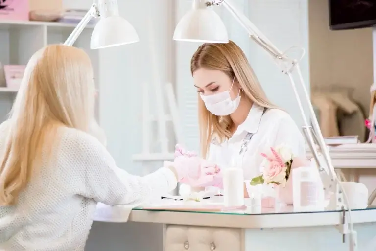 Kvinde får lavet en manicure i en salon