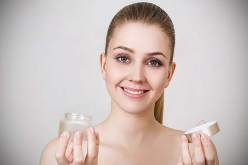 Smilende kvinde står med creme i hænderne