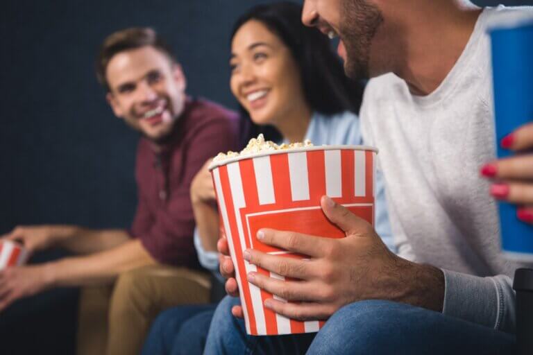 Venner nyder en film og popcorn sammen